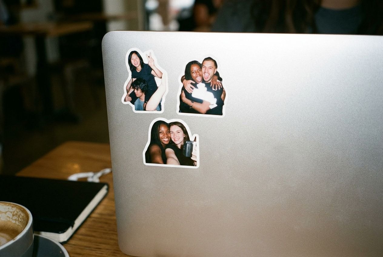 Small die-cut photo stickers on the corner of a laptop lid