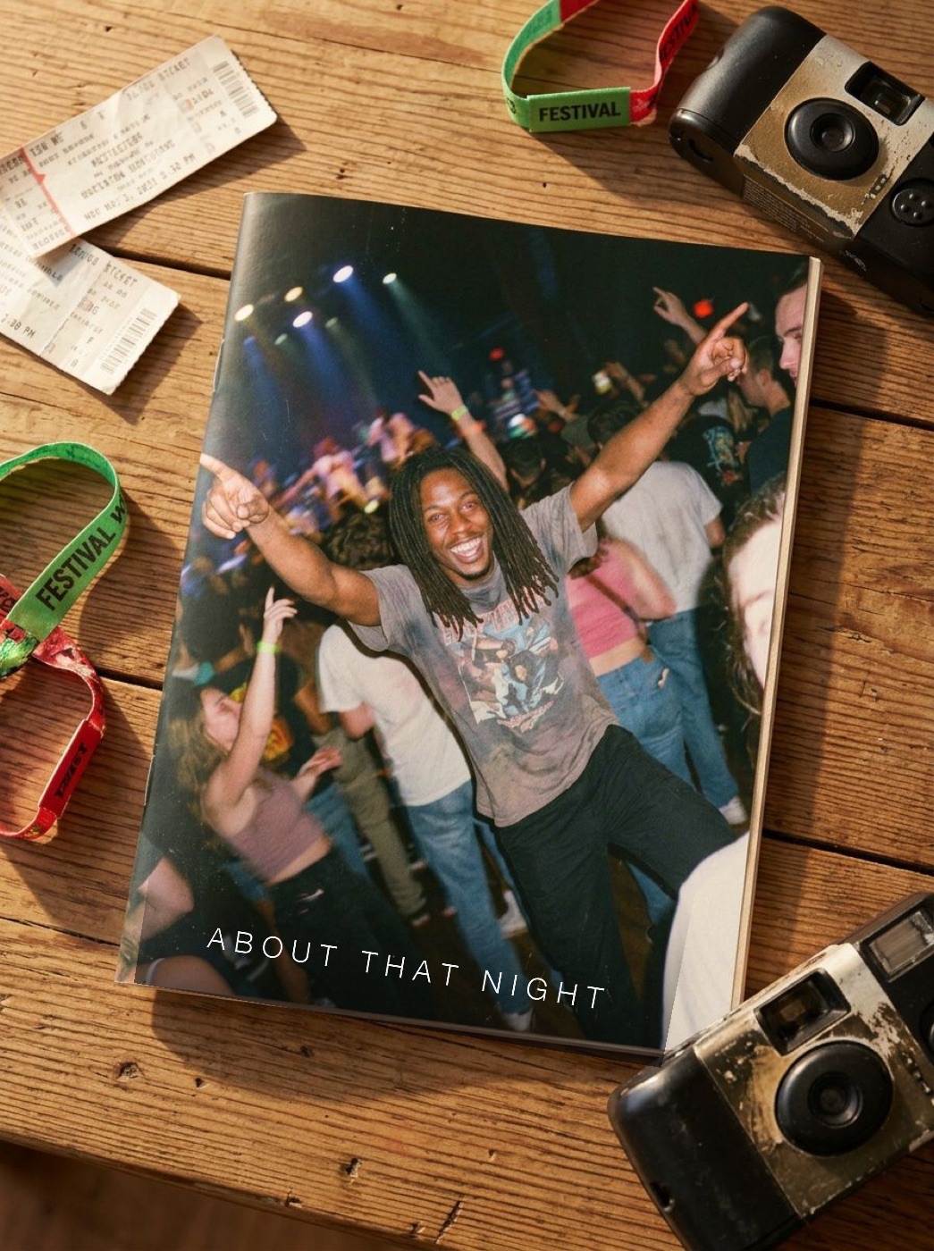 The printed zine on a table with ticket stubs, wristbands, and disposable cameras